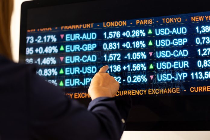 Computer,Monitor,With,Currency,Exchange,Rates.,Woman,Points,Her,Finger